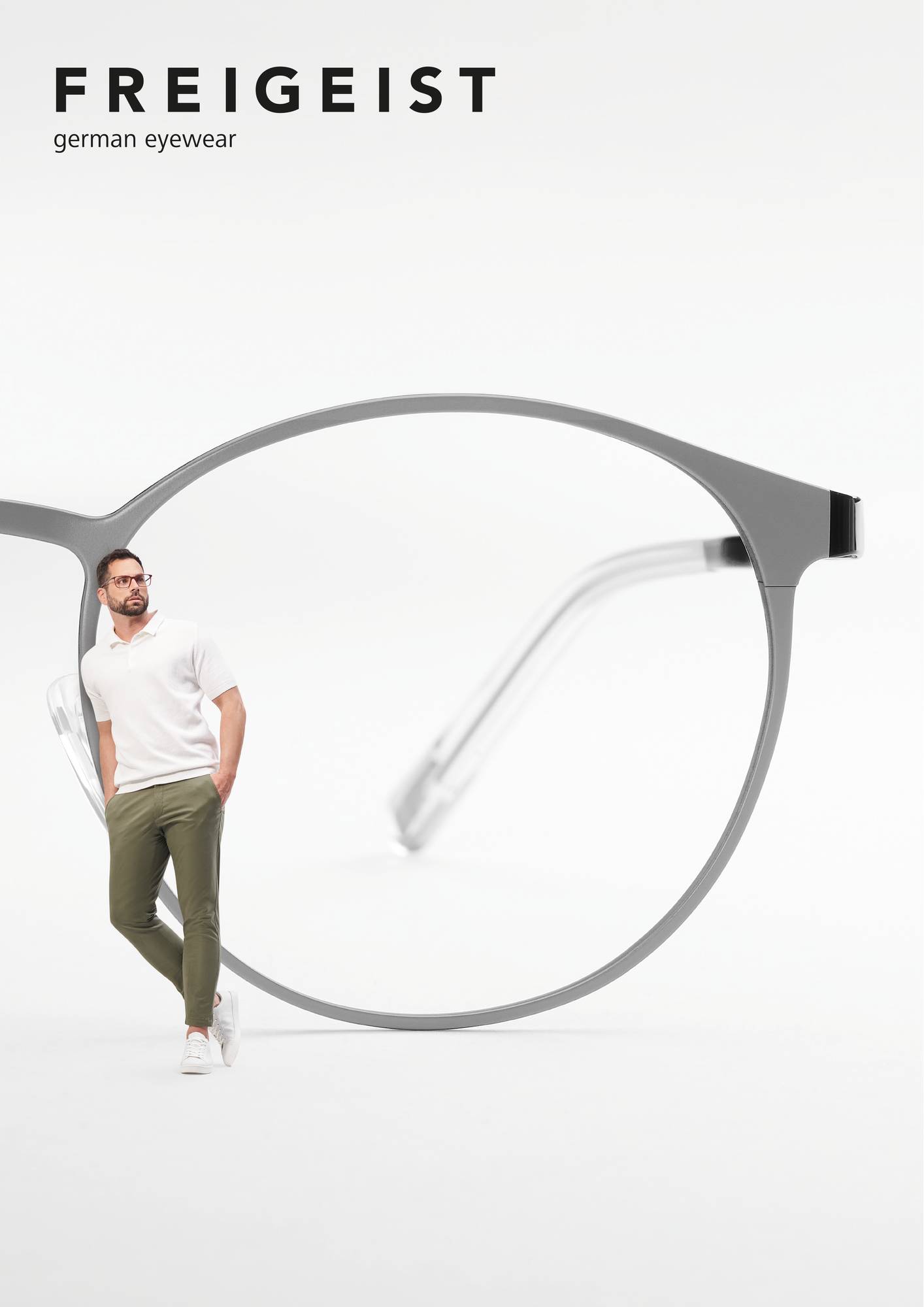 Ein Mann lehnt an einem überdimensionalen Sehbrille von FREIGEIST Brillen.